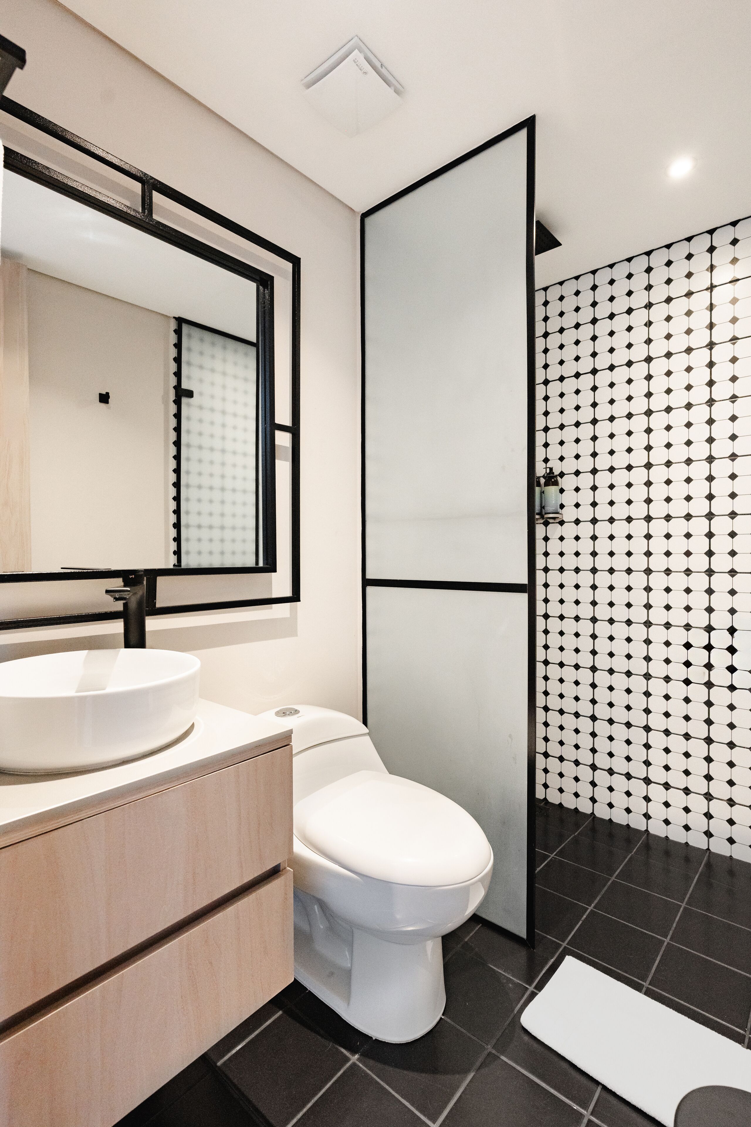 A modern bathroom with a white sink, a toilet, and a shower area.