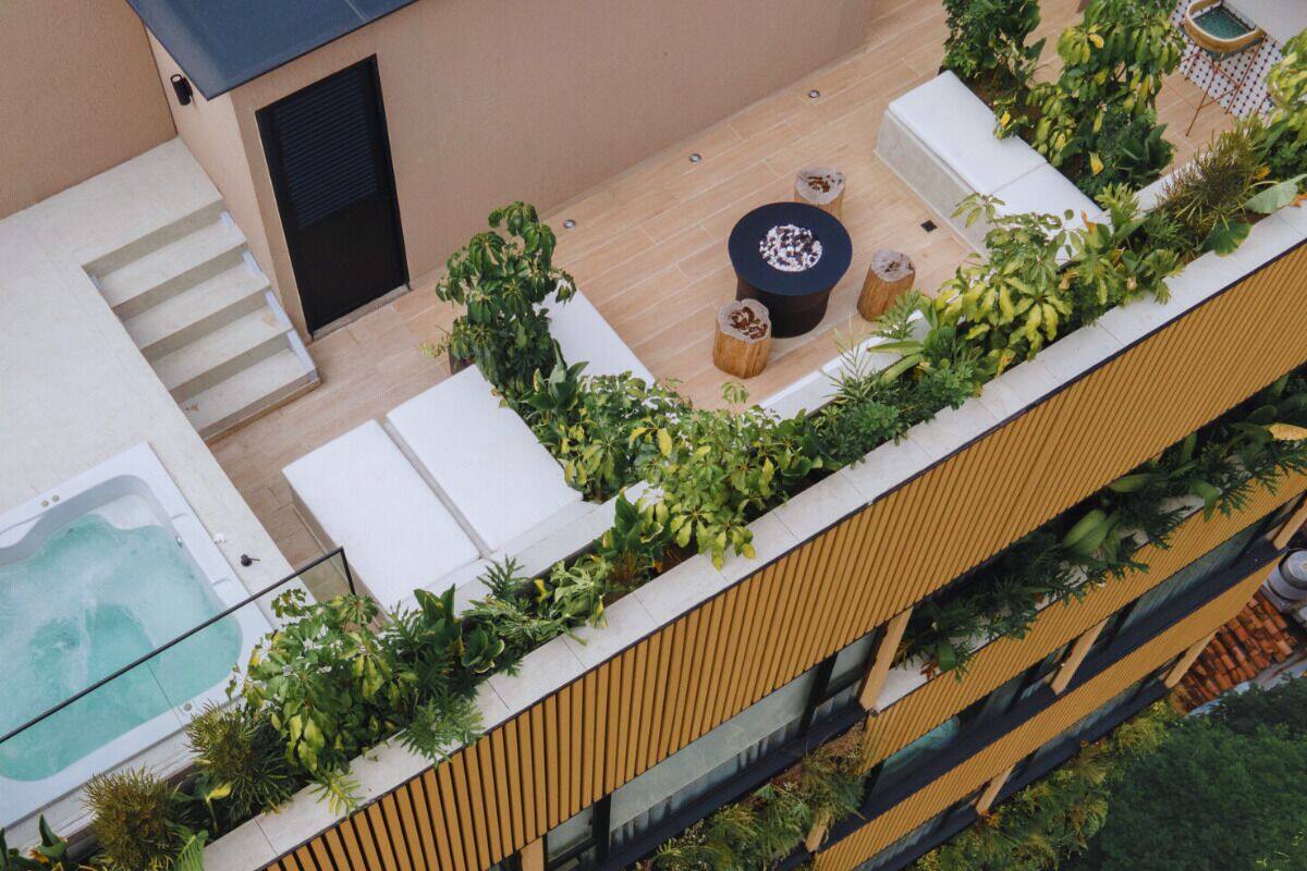 Eine Dachterrasse mit Whirlpool, Sitzgelegenheit und üppiger Bepflanzung.