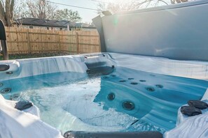 A hot tub with a wooden fence in the background. - OliveBranch-LuxeDesigner Home-Spa-Firepit-GameZone (Greenwood)