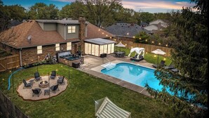 A backyard with a swimming pool, a hot tub, and outdoor seating. - Zestlife-HeatedPool-LuxeEscp-ThemedRooms-GameRoom (Indianapolis)