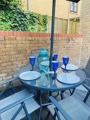 Enjoy dining al fresco in this charming outdoor space with a round table and comfortable seating for four.