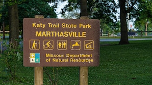 Placa para o Parque Estadual Katy Trail em Marthaville, Missouri, indicando atividades de caminhada, ciclismo e camping.