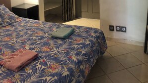 Un dormitorio con cama, armario y mesita de noche.