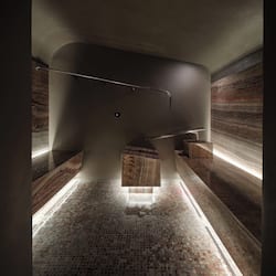 Bathroom features a large mirror, bench, and mosaic-tiled floor.