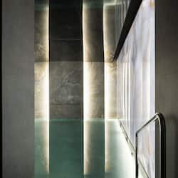 Experience a serene space with a sleek floor, glass partition, and metal handrail.