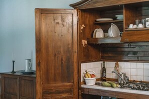 Una cocina con armarios de madera, un lavamanos y una cesta de frutas.