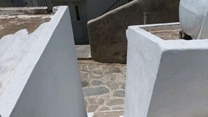 A staircase with white-painted walls and stone steps. - A fully air con 2-bedroom apartment,a cosy living room,fully equipped kitchen. (Tinos)
