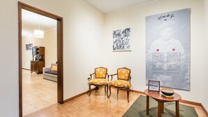 Ein Empfangsbereich mit zwei Sesseln, einem gerahmten Willkommen-Schild und einem großen Poster an der Wand.