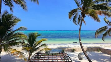 On the beach, white sand, sun-loungers, beach umbrellas