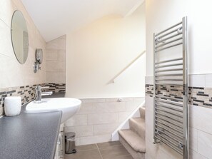 Ein modernes Badezimmer mit Waschbecken, Spiegel und Handtuchhalter.