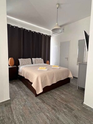 A modern bedroom with a bed, bedside tables, a desk, and a mirror. - Studio with air conditioning and sea view (Crikvenica)