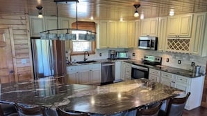 A kitchen with a large island, stainless steel appliances, and wooden cabinetry. - SPACIOUS Lakeside Home in the perfect LOCATION near all the action! (LaFollette)