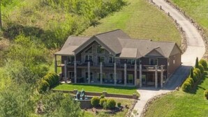 A large, two-story house with a prominent front porch, a driveway, and a landscaped lawn. - SPACIOUS Lakeside Home in the perfect LOCATION near all the action! (LaFollette)