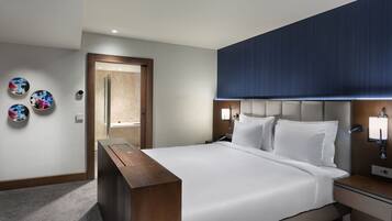 Una camera d'hotel moderna con un letto grande, comodini, una panca in legno e decorazioni a parete.