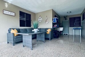 A living area with a sofa, a coffee table, and a potted plant.