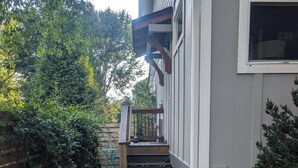 Ein Kiesweg führt zu einem Haus mit einer Holzveranda und Stufen.
