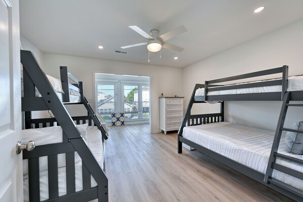A room with bunk beds, a ceiling fan, and a view of the outdoors. - Private Home - 1 Block to ocean- Private Fenced in Yard - Pet Friendly (North Myrtle Beach)