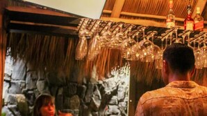 A bar area with a rustic stone wall and hanging wine glasses. - Casa Pepe Hostel Boutique - Sayulita (Sayulita)