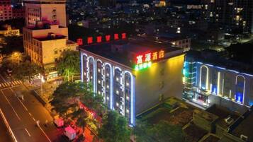 Un hotel con fachada moderna, señalización iluminada y una entrada destacada.