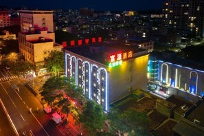 A hotel with a modern facade, illuminated signage, and a prominent entrance. - fuyuzhihui Hotel (Wanning)