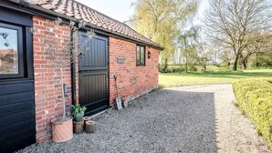 A brick building with a black door and windows, a gravel driveway, and a well-maintained hedge. - The Studio, Ivy Lodge Barn, Hoo (Hoo)