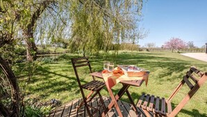 An outdoor dining area with a table and chairs, surrounded by greenery and trees. - The Studio, Ivy Lodge Barn, Hoo (Hoo)