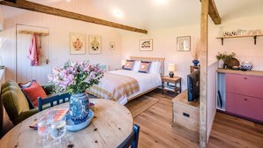 A cozy bedroom with a bed, bedside table, and a small kitchenette area. - The Studio, Ivy Lodge Barn, Hoo (Hoo)