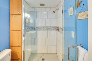A shower with glass doors, a wooden cabinet, and a towel rack with a sign. - Pool Access: Oceanfront Myrtle Beach Getaway! (Myrtle Beach)