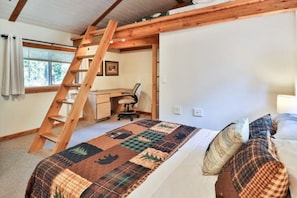 Une chambre à coucher avec un lit, un bureau, une chaise, une échelle et une fenêtre.