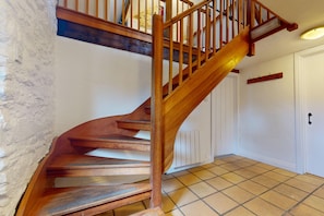 A wooden staircase with a handrail leading to a landing.