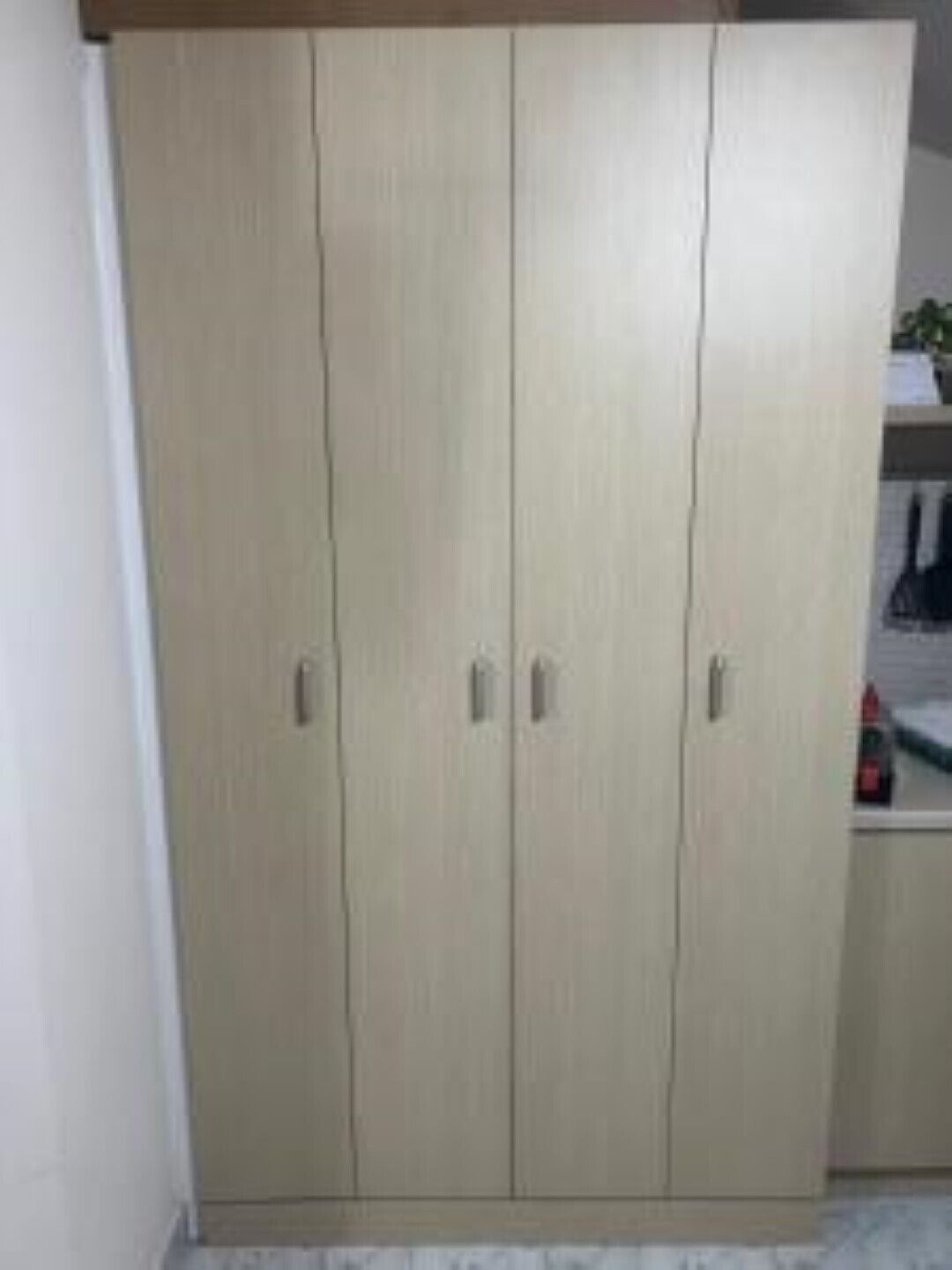 A large wardrobe with three doors and a shelf above.