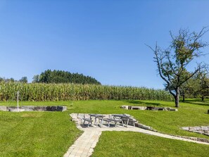 Un espacio con césped y un sendero de piedra que lleva a una mesa de picnic.