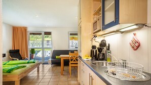 Une cuisine compacte avec un coin repas, un canapé et un lit.