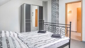 Un dormitorio con cama, armario y chimenea de ladrillo.