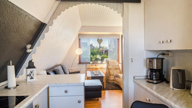 Una cocina compacta con cafetera, tostadora y ventana con vistas a zonas verdes.