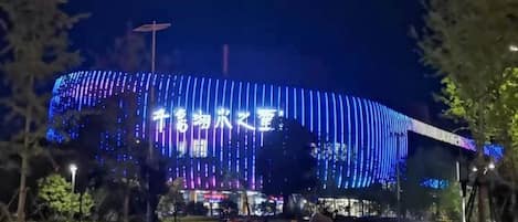 A large building with illuminated signage and a curved structure.