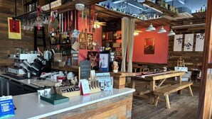 Een restaurantinterieur met houten meubels, een toonbank met diverse spullen en hangende decoraties.