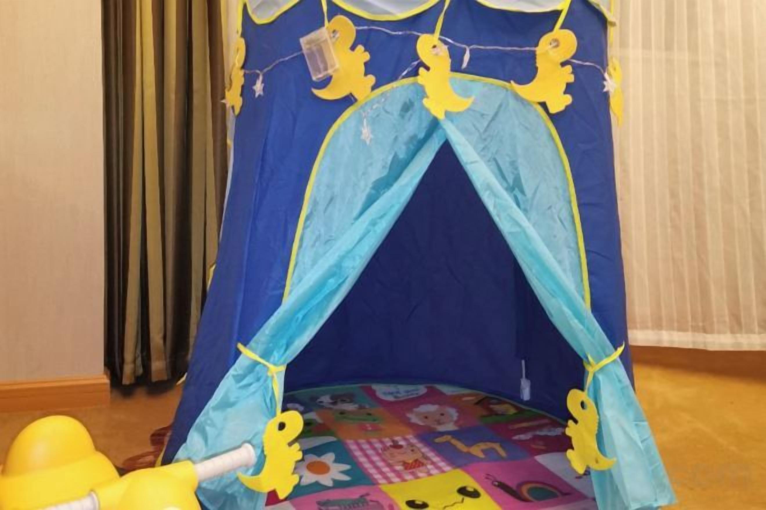 A children's play tent with a blue and yellow design, featuring cartoon characters on the floor.