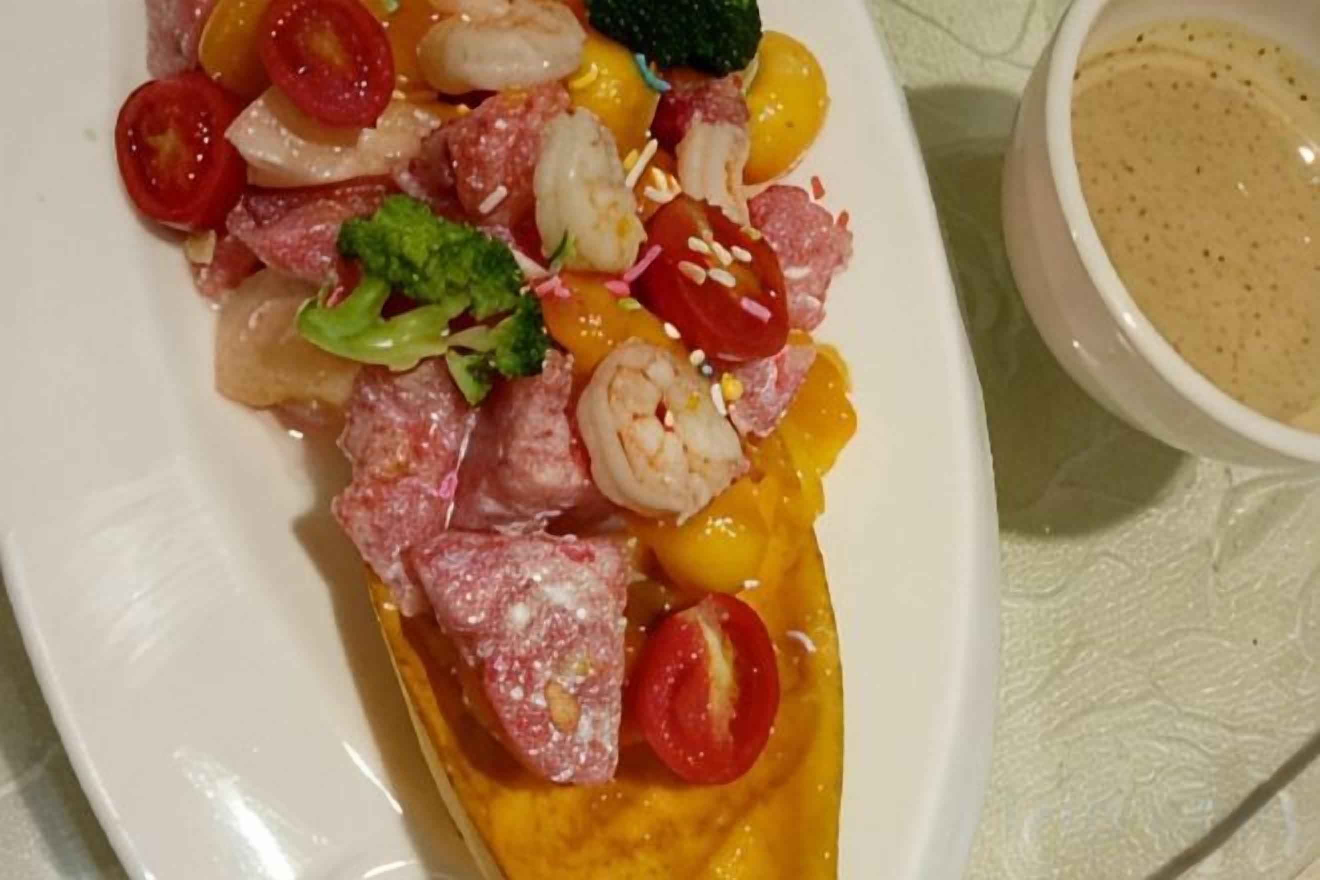 Un plato de comida con diversos ingredientes, como camarones, carne y verduras.