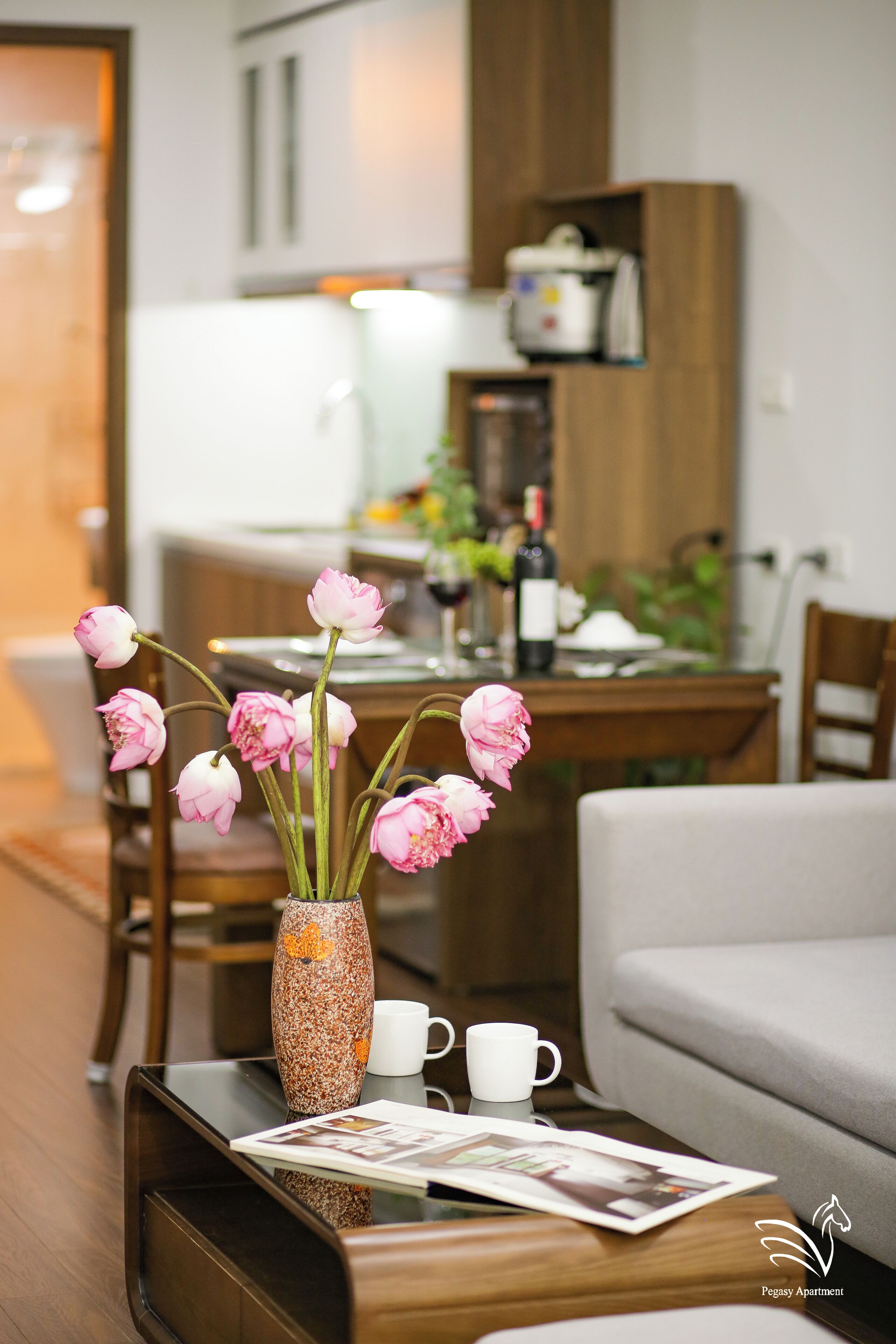 Un soggiorno moderno con un tavolino, un vaso con fiori e un'area pranzo sullo sfondo.