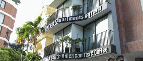 A multi-story building with a sign for 'Pegasy Apartments & Coffee' featuring a South American Tea & Coffee shop.