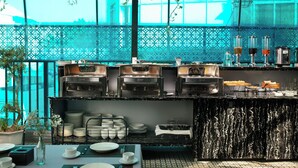 A modern cafe with a bar area, coffee machines, and a decorative plant arrangement. - Pegasy Apartments & Travel (Hanoi)