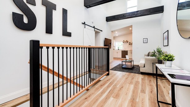 Ein modernes Interieur mit Treppe, Küchenbereich und einer Sitzecke.