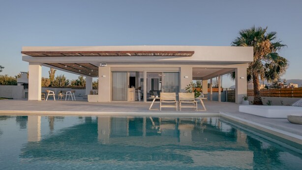 Ett modernt hus med en swimmingpool, utomhusmöbler och en täckt uteplats.