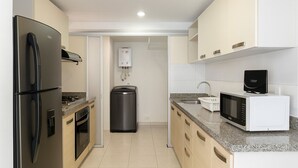 Eine moderne Küche mit Edelstahlgeräten, einem eingebauten Backofen, einer Mikrowelle und einem Durchlauferhitzer.