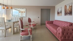 A modern living room with a pink sofa, a dining table with chairs, and a large mirror. - Nice view of the mountains in the north of Cali (Cali)