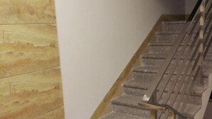 A staircase with stone steps and a wooden handrail. - Shangxi Apartment (Zhaoqing)