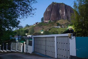 A large rock formation with a building on top, surrounded by a gated area with a fence and street lamps. - Lakeview Cabin with Jacuzzi in Guatapé (Guatapé)