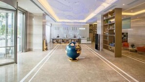 A spacious lobby with a large globe centerpiece, a reception desk, and a modern interior design. - Guiyi Hotel (Guiyang Guanshanhu District Southwest International Trade City Store) (Guiyang)