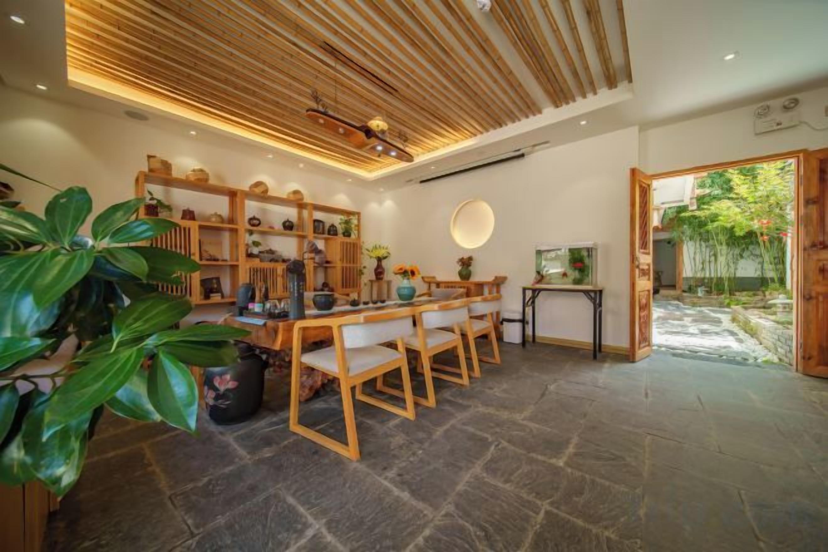 A dining area with a wooden table and chairs, surrounded by shelves with various items.